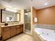 Spa-like bathroom with a soaking tub, walk-in shower, and granite vanity at 12544 Floridays Resort Dr # 202B, Orlando, FL 32821