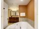 Bathroom with corner jetted tub and wood vanity at 12544 Floridays Resort Dr # 202B, Orlando, FL 32821