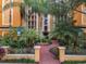 Building entrance with landscaped courtyard and walkway at 12538 Floridays Resort Dr # C-211, Orlando, FL 32821