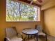 Small balcony with table and chairs, offering a view of the trees at 12538 Floridays Resort Dr # C-211, Orlando, FL 32821