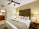 King-size bed, nightstands, ceiling fan, and access to bathroom at 12538 Floridays Resort Dr # C-211, Orlando, FL 32821