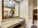 Vanity with granite countertop, mirror and view of kitchen at 12538 Floridays Resort Dr # C-211, Orlando, FL 32821