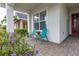 Relaxing front porch with two teal chairs and colorful flowers at 5012 E Fountainwood Dr, Saint Cloud, FL 34772