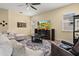 Spacious living room with beige sofas, large TV, and access to backyard patio at 5012 E Fountainwood Dr, St Cloud, FL 34772