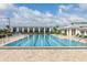 Community lap pool with surrounding lounge chairs and patio area at 5012 E Fountainwood Dr, St Cloud, FL 34772