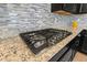 Close-up of a gas cooktop with granite countertop at 5012 E Fountainwood Dr, St Cloud, FL 34772