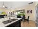 Kitchen island with granite and sink overlooks casual dining area with sliding glass doors to backyard at 5012 E Fountainwood Dr, St Cloud, FL 34772
