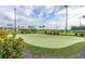 Landscaped putting green with surrounding plants and a paved path at 5012 E Fountainwood Dr, St Cloud, FL 34772