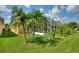 Screened patio with lush landscaping and palm trees at 220 Lewis Dr, Davenport, FL 33837