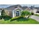 Tan house with gray roof, landscaping, and paved driveway at 220 Lewis Dr, Davenport, FL 33837