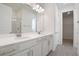 Double vanity bathroom with white cabinets, gray tile floors, and a walk-in shower at 4056 Bannock Ave, Tavares, FL 32778