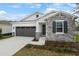 New single-story home with stone and shingle accents, two-car garage, and landscaped front yard at 4056 Bannock Ave, Tavares, FL 32778