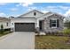 New single-story home with stone and shingle accents, two-car garage, and landscaped front yard at 4056 Bannock Ave, Tavares, FL 32778