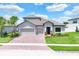Two-story house with gray exterior, two-car garage, and landscaped yard at 3875 Bowfin Trl, Kissimmee, FL 34746
