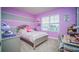 Bedroom with purple walls, full-size bed, and desk at 2378 White Lilly Dr, Kissimmee, FL 34747