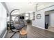 Open living area with gray walls, wood flooring, and a hanging chair at 104 Langham Dr, Davenport, FL 33897
