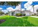 Charming light blue home with green landscaping and a palm tree at 104 Langham Dr, Davenport, FL 33897