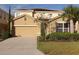 Two-story house with attached garage and landscaping at 5265 Oakbourne Ave, Davenport, FL 33837