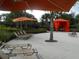 Spacious pool deck with orange umbrellas and lounge chairs at 5265 Oakbourne Ave, Davenport, FL 33837