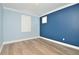 Light blue bedroom with wood-look floors, white trim, and a blue accent wall at 1862 Beach Ridge Rd, Celebration, FL 34747