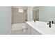 Modern bathroom with double vanity, grey tile, and a shower/tub combo at 1862 Beach Ridge Rd, Celebration, FL 34747