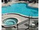 Community pool and spa with surrounding patio furniture at 3100 Parkway Blvd # 712, Kissimmee, FL 34747