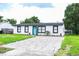 Newly renovated home with a modern exterior, paver driveway, and lush lawn at 1411 Overdale St, Orlando, FL 32825