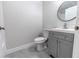 Updated bathroom with gray vanity, white toilet and a modern round mirror at 1411 Overdale St, Orlando, FL 32825
