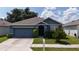 Single story home with blue siding and attached garage at 5569 Oro Valley Rd, Auburndale, FL 33823