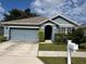 Single-story home with blue siding, attached garage, and well-maintained landscaping at 5569 Oro Valley Rd, Auburndale, FL 33823