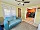 Sunroom with a teal couch and a view into the kitchen at 1206 Osceola Ave, Tavares, FL 32778