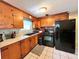 Updated kitchen with wood cabinets, black appliances, and tiled floors at 1206 Osceola Ave, Tavares, FL 32778