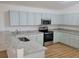 Modern kitchen with light blue cabinets, granite countertops, and stainless steel appliances at 1025 W Lake Hamilton Dr, Winter Haven, FL 33881