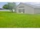 Spacious backyard with grassy lawn and mature tree at 1025 W Lake Hamilton Dr, Winter Haven, FL 33881
