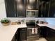 Modern kitchen with dark cabinets, stainless steel appliances, and white countertops at 9355 Sommerset Hills Dr # 9355, Davenport, FL 33896