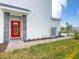 View of a modern townhome's entrance with a red door and stone accents at 9355 Sommerset Hills Dr # 9355, Davenport, FL 33896