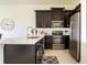 Modern kitchen with dark cabinetry, stainless steel appliances, and an island at 9355 Sommerset Hills Dr # 9355, Davenport, FL 33896