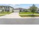 House exterior features a gray color scheme, two-car garage, and well-manicured lawn at 2807 Harmonia Hammock Rd, Harmony, FL 34773