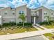 Modern two-story townhome with gray siding, stone accents, and teal front door at 4222 Paragraph Dr, Kissimmee, FL 34746