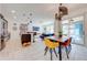 Mid-century modern dining area with wood table and colorful chairs, open to the kitchen at 4222 Paragraph Dr, Kissimmee, FL 34746