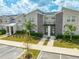 Modern two-story townhome with gray siding, stone accents, and teal front door at 4222 Paragraph Dr, Kissimmee, FL 34746