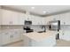 Modern kitchen with white cabinets, quartz countertops, and stainless steel appliances at 1732 Carnelian St, Deland, FL 32720