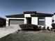 One-story home with gray garage door and landscaping at 185 Brookes Pl, Haines City, FL 33844