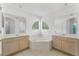 Bathroom with double vanity, corner bathtub, and mirrored walls at 1556 N Hampton Dr, Davenport, FL 33897