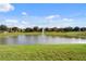 Serene pond with fountain, surrounded by lush greenery and townhomes at 1556 N Hampton Dr, Davenport, FL 33897