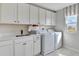 Well-equipped laundry room with white cabinets and modern appliances at 310 Alexandrite St, Deland, FL 32720