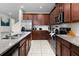 Modern kitchen with dark wood cabinets and granite countertops at 9032 Flamingo Key Way, Kissimmee, FL 34747