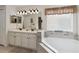 Bathroom with double vanity and large soaking tub at 241 Grosvenor Loop, Davenport, FL 33897