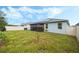 Home's backyard view with grassy area and solar panels at 6282 Lakepine St, Saint Cloud, FL 34771