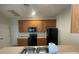Kitchen with wood cabinets and black appliances at 4980 W Castle W St, Kissimmee, FL 34758